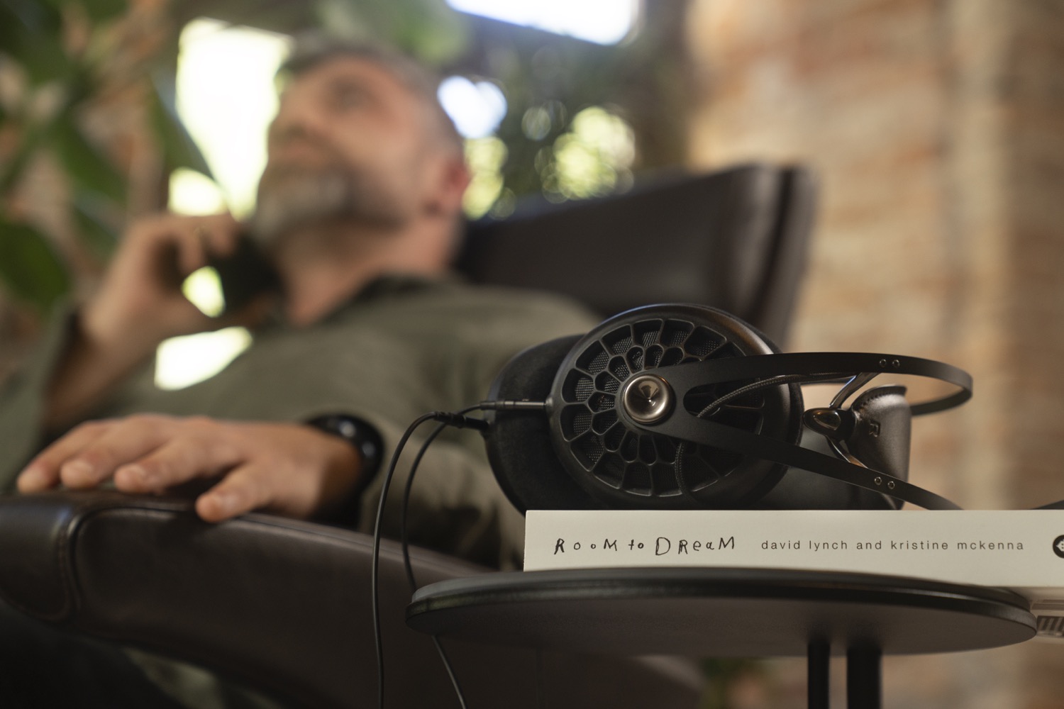 Photo of man sitting in a chair next to 105 AER on a stack of books