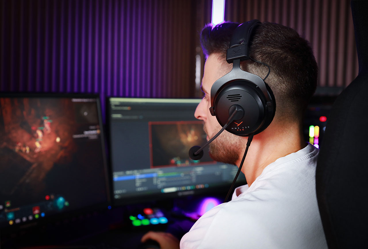 Side profile of male gamer wearing MMX 330 Pro while staring at computer display